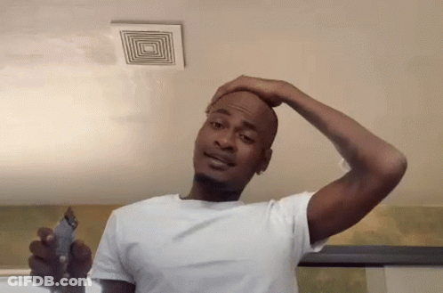 A Man In A White Shirt Is Shaving His Head With A Trimmer . GIF