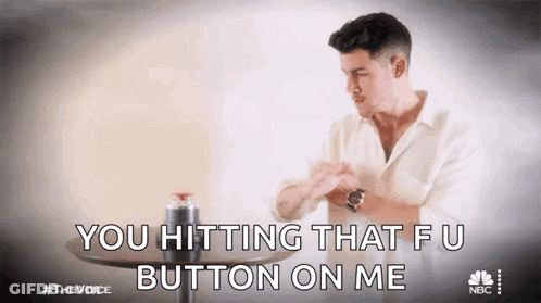 A Man In A White Shirt Is Sitting At A Table And Saying You Hitting That Fu Button On Me GIF
