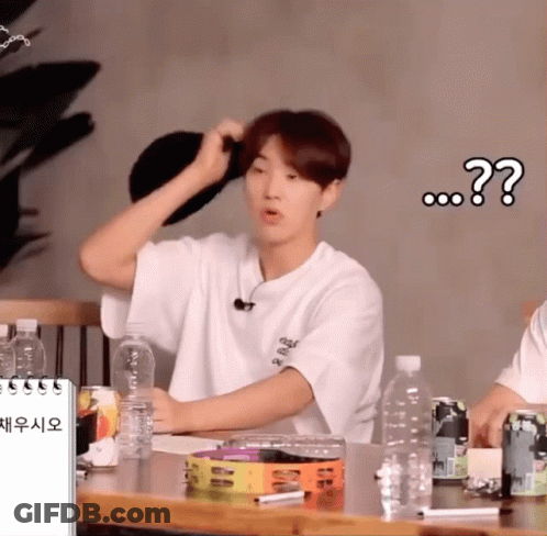 A Man In A White Shirt Is Sitting At A Table With A Bottle Of Water In Front Of Him And A Question Mark Above Him GIF
