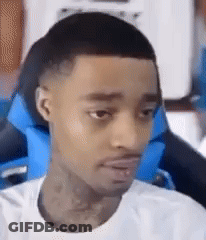 A Man In A White Shirt Is Sitting In A Blue Chair . GIF