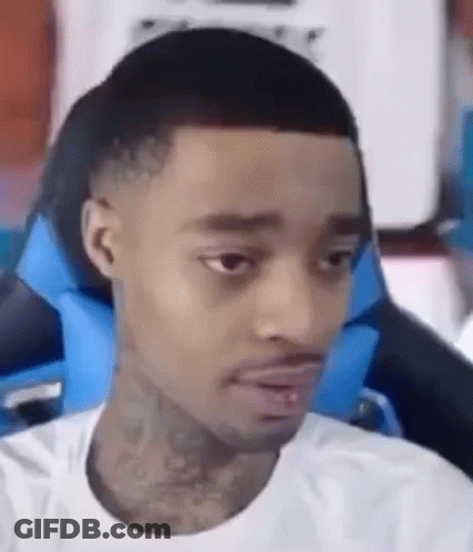 A Man In A White Shirt Is Sitting In A Blue Chair . GIF