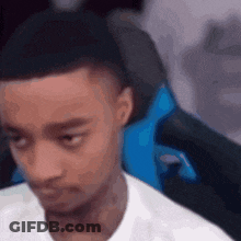 A Man In A White Shirt Is Sitting In A Blue Gaming Chair . GIF