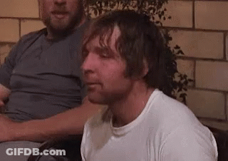 A Man In A White Shirt Is Sitting In A Chair Next To Another Man In A Gray Shirt . GIF