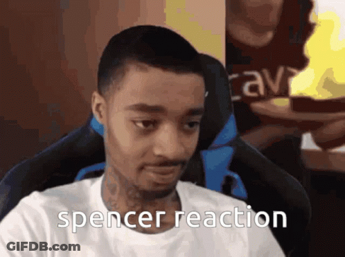 A Man In A White Shirt Is Sitting In A Chair With The Words Spencer Reaction Below Him GIF