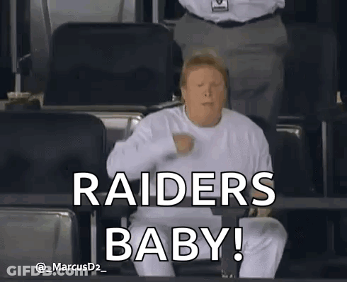 A Man In A White Shirt Is Sitting In A Stadium And Says " Raiders Baby " . GIF