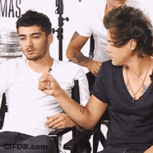 A Man In A White Shirt Is Sitting Next To Another Man In A Black Shirt GIF