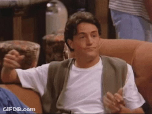 A Man In A White Shirt Is Sitting On A Couch With His Arms Outstretched GIF