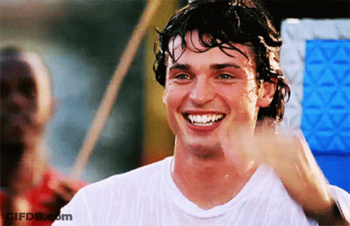 A Man In A White Shirt Is Smiling And Waving At Someone GIF