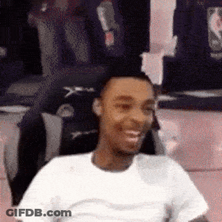 A Man In A White Shirt Is Smiling In Front Of A Mirror GIF