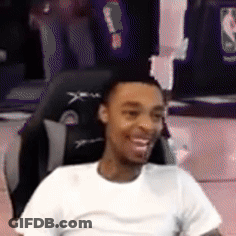 A Man In A White Shirt Is Smiling While Sitting In A Gaming Chair . GIF