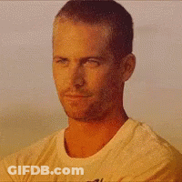 A Man In A White Shirt Is Smiling With His Eyes Closed And His Mouth Open . GIF