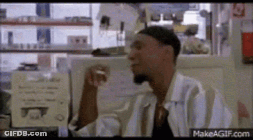 A Man In A White Shirt Is Smoking A Cigarette In A Diner . GIF