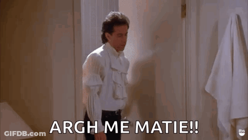 A Man In A White Shirt Is Standing In A Bathroom And Saying Argh Me Matie ! GIF