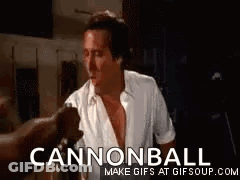 A Man In A White Shirt Is Standing In A Dark Room With A Cannonball Gif . GIF