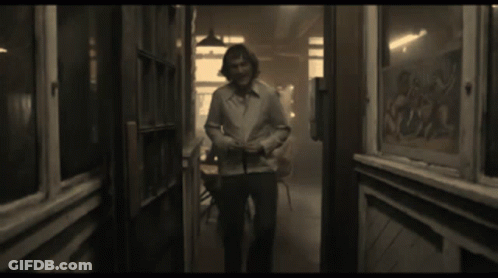 Man In White Shirt Smiling In Hallway GIF