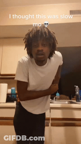 A Man In A White Shirt Is Standing In A Kitchen With The Words I Thought This Was Slow Mo On The Bottom GIF