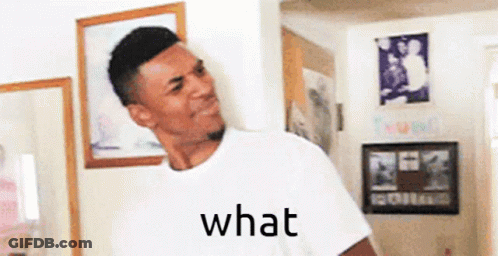 A Man In A White Shirt Is Standing In A Room With A Picture On The Wall And The Word What Written On It . GIF