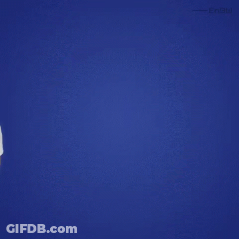 A Man In A White Shirt Is Standing In Front Of A Blue Background Looking Up . GIF