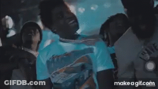 A Man In A White Shirt Is Standing In Front Of A Crowd With Make A Gif.com On The Bottom Right GIF
