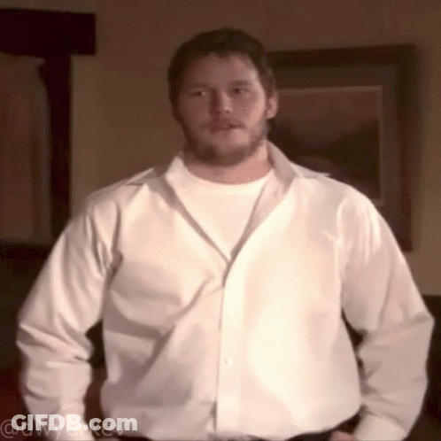 A Man In A White Shirt Is Standing In Front Of A Framed Picture And Has The Username @Dwyerkev On The Bottom GIF