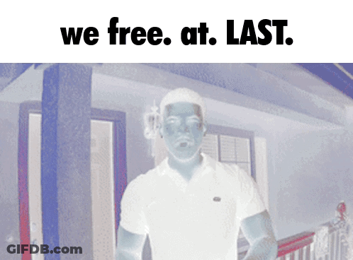 A Man In A White Shirt Is Standing In Front Of A House With The Words " We Free At Last " Above Him GIF