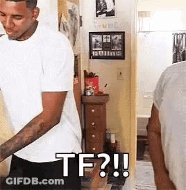 A Man In A White Shirt Is Standing In Front Of A Mirror In A Room And Says `` Tf ? '' . GIF