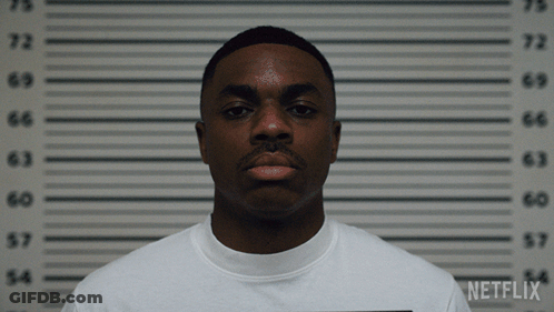 A Man In A White Shirt Is Standing In Front Of A Netflix Wall GIF