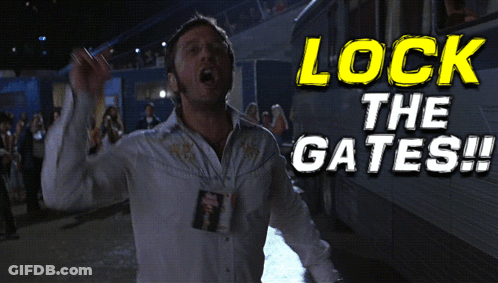 A Man In A White Shirt Is Standing In Front Of A Sign That Says " Lock The Gates " GIF