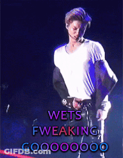 A Man In A White Shirt Is Standing In Front Of A Sign That Says Wets Fweaking Goo00000 GIF