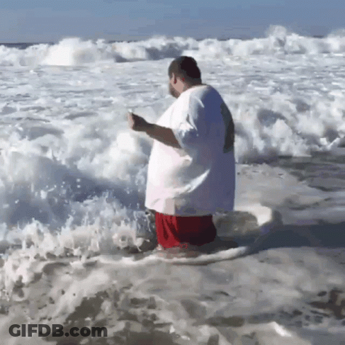 A Man In A White Shirt Is Standing In The Water GIF