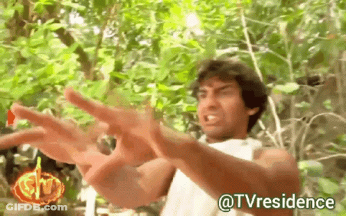 A Man In A White Shirt Is Standing In The Woods With His Arms Outstretched And The Words @Tvresidence Below Him GIF