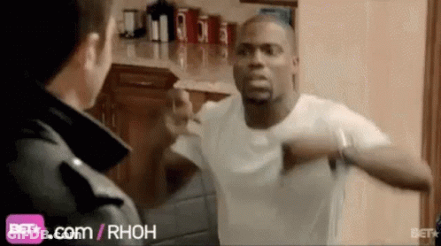 A Man In A White Shirt Is Standing Next To A Man In A Black Jacket . GIF