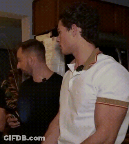 A Man In A White Shirt Is Standing Next To A Man In A Black Shirt GIF
