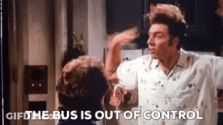 A Man In A White Shirt Is Standing Next To Another Man In A Kitchen And Says The Bus Is Out Of Control . GIF