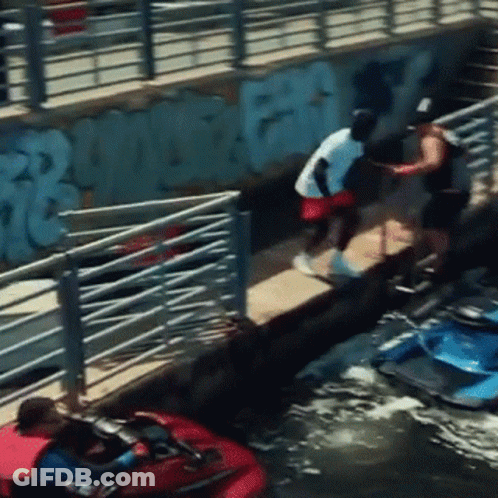 A Man In A White Shirt Is Standing On A Dock Next To A Jet Ski GIF