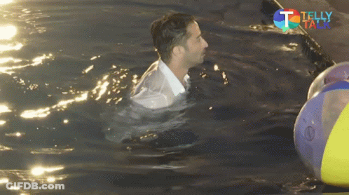 A Man In A White Shirt Is Swimming In A Pool With A Telly Talk Logo In The Background GIF
