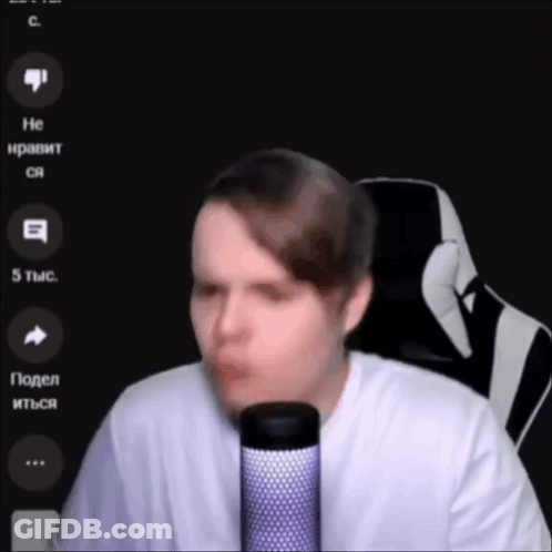 A Man In A White Shirt Is Talking Into A Microphone . GIF
