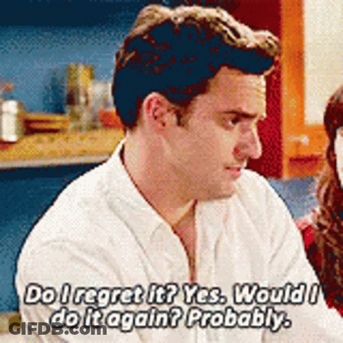 A Man In A White Shirt Is Talking To A Woman In A Kitchen . GIF