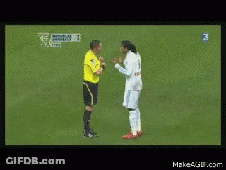 A Man In A White Shirt Is Talking To Another Man In A Yellow Shirt With The Number 3 On The Bottom Right GIF