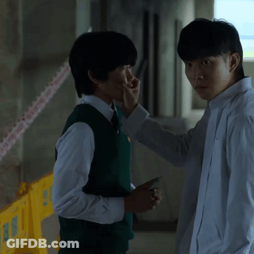 A Man In A White Shirt Is Touching Another Man 'S Face With His Hand GIF