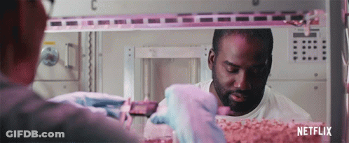 A Man In A White Shirt Is Working In A Room With Netflix Written On The Bottom GIF