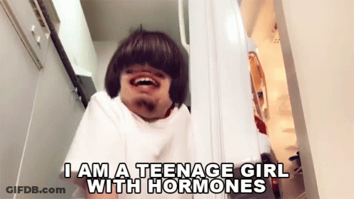 A Man In A White Shirt Says " I Am A Teenage Girl With Hormones " While Looking Into A Refrigerator GIF