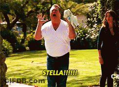 A Man In A White Shirt Shouts Stella While Holding A Pair Of Shoes GIF