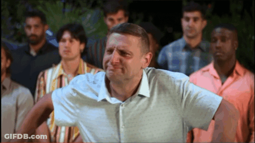 A Man In A White Shirt Stands In Front Of A Crowd Of Men GIF