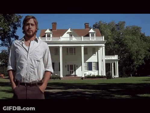 A Man In A White Shirt Stands In Front Of A Large White House GIF