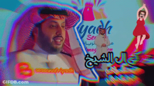 A Man In A White Shirt Stands In Front Of A Sign That Says Yash GIF