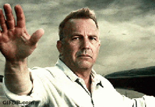 A Man In A White Shirt Waves His Hand In The Air GIF