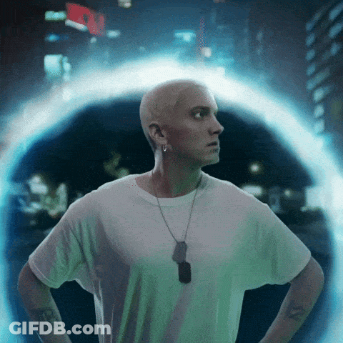 A Man In A White Shirt With A Dog Tag Around His Neck Is Standing In Front Of A Portal GIF