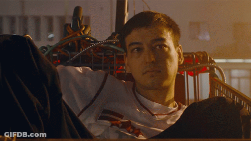 A Man In A White Shirt With A Red And White Stripe On The Sleeves GIF