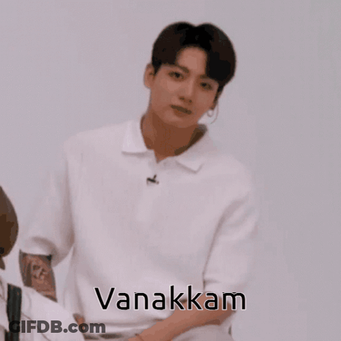 A Man In A White Shirt With His Hands Folded And The Word Vanakkam On The Bottom GIF
